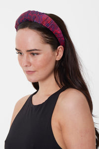 Model wearing a marble red printed Fire Ocean silk satin padded headband that is elegant and glamorous