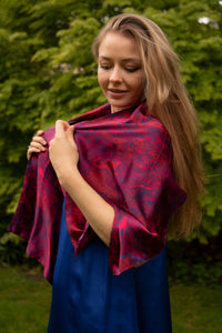 Side view of model wearing long double-sided silk satin scarf in red marble print.