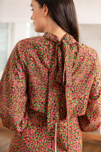 Tie collar detail back view of halter neck silk bamboo top with long raglan sleeves in dotted orange/pink print.