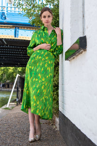Model wearing a colourful green and yellow silk printed Isabel Manns narrow a-line midi skirt with wide waistband, worn with matching Lisa Shirt.