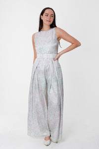 An Isabel Manns sleeveless wide leg silk cotton jumpsuit and matching belt that comes in a pastel blue print.