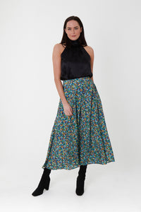 Model wearing a-line midi silk bamboo green multicoloured printed skirt, worn with black halter neck Sophie Top.