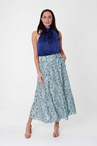 Model wearing a-line midi silk bamboo pale green printed skirt, worn with navy halter neck Sophie Top.