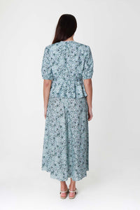 Back view of model wearing a-line midi silk bamboo pale green printed skirt, worn with matching wrap Judy Top.