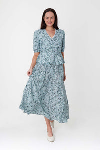 Model wearing a-line midi silk bamboo pale green printed skirt, worn with matching wrap Judy Top.