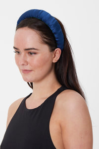 a classic navy padded headband that has a dotted texture to the fabric making it timeless and versatile worn by a model