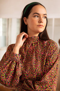 An Isabel Manns halter neck silk bamboo top with long raglan sleeves with tie collar in dotted orange/pink print.