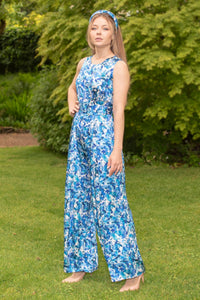 An Isabel Manns sleeveless wide leg silk satin jumpsuit and matching belt that comes in a vibrant blue print.