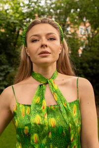 Model wearing narrow silk satin scarf in green and yellow print, with matching padded headband and Ellie dress.