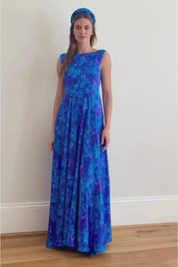 a video showing the stunning blue floral long gown with low v back on a model as she walks the a-line style volume is accentuated 