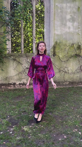 Video of red marble printed silk satin halter neck dress with keyhole neckline, long elasticated sleeves and a tie belt worn by a model