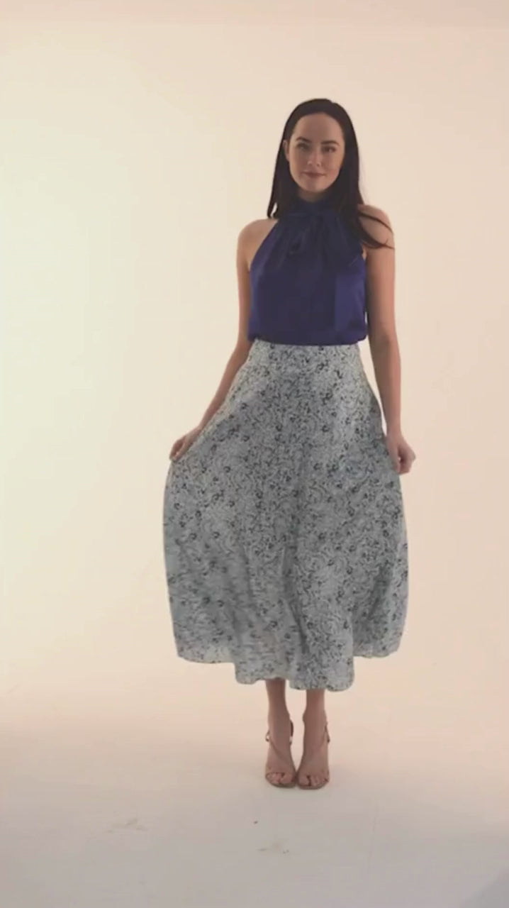 Video of model wearing a-line midi silk bamboo pale green printed skirt, worn with navy halter neck Sophie Top.