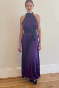 a women walking back and forth into the camera to showcase the elegance of this purple silk satin reversible halter neck long dress