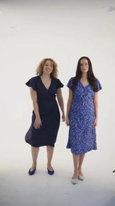 a video of two models showing the reversible wrap dress on a blue floral printed side and plain navy side