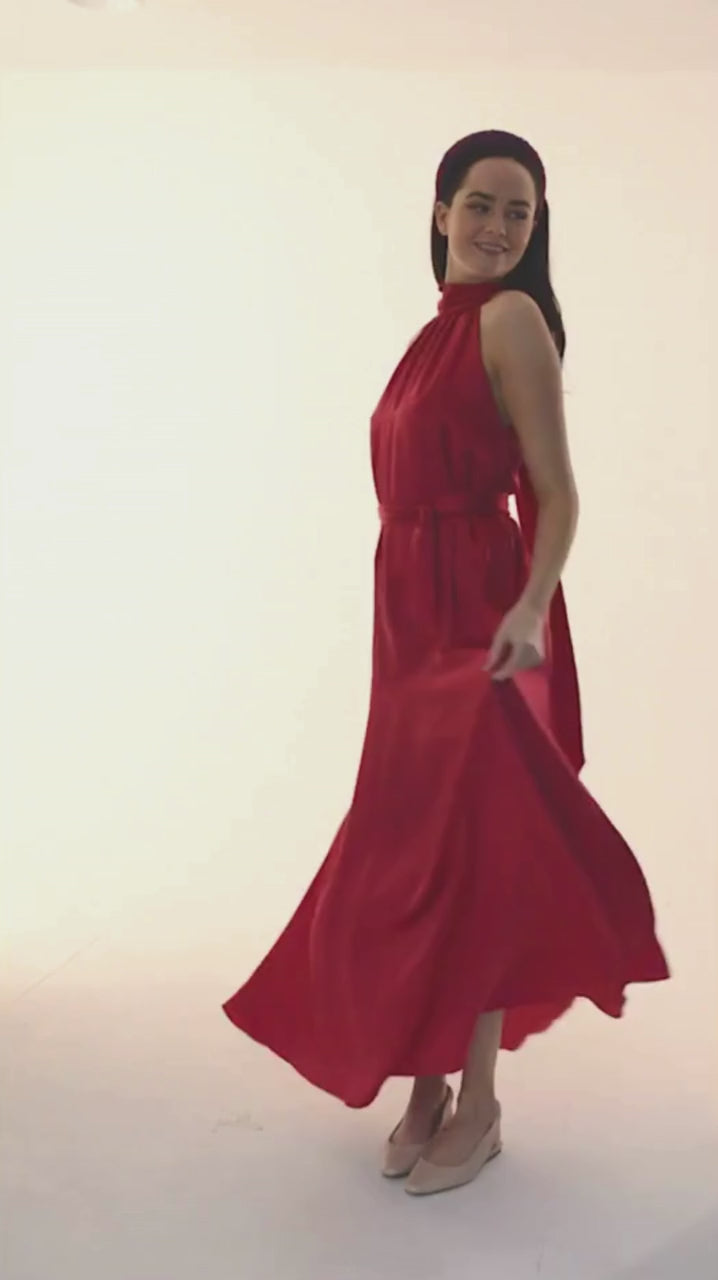 a model moving in a dark pink satin halter neck dress