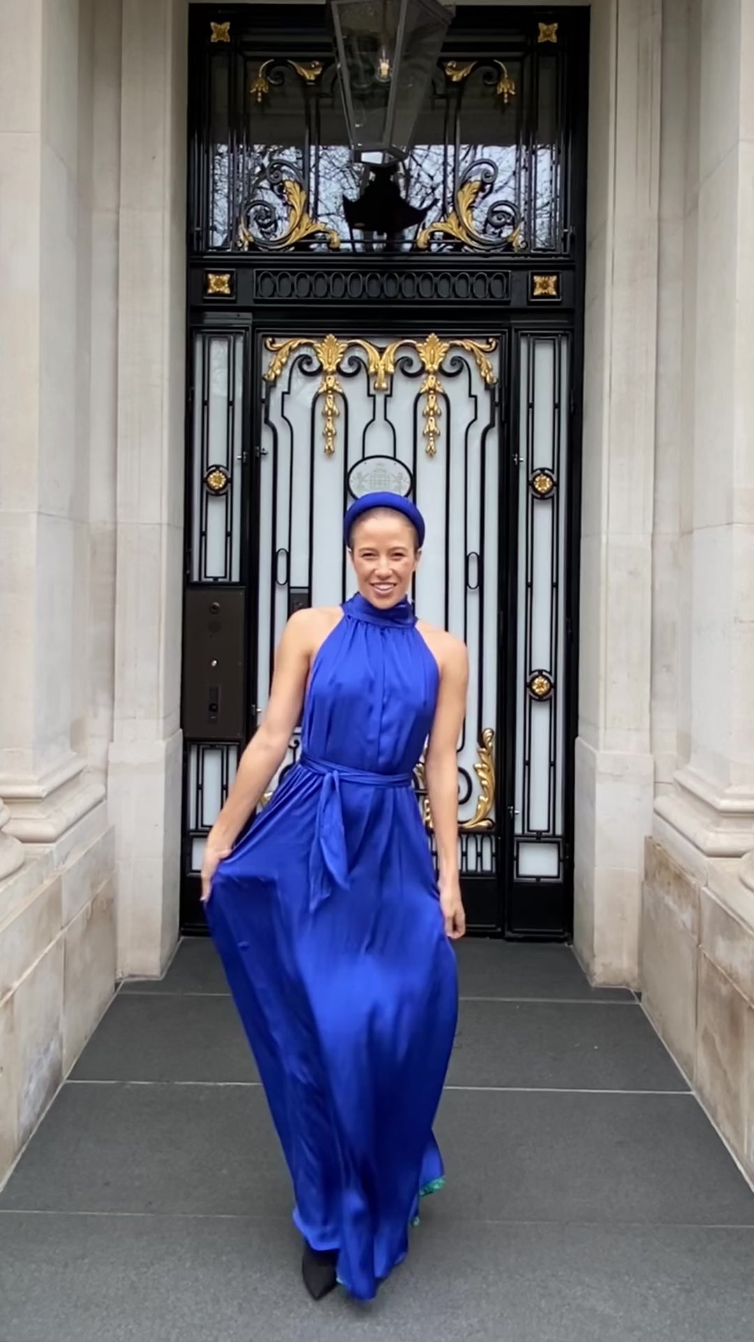 a video showing the blue long silk satin halter neck dress in motion as it elegantly moves by a model