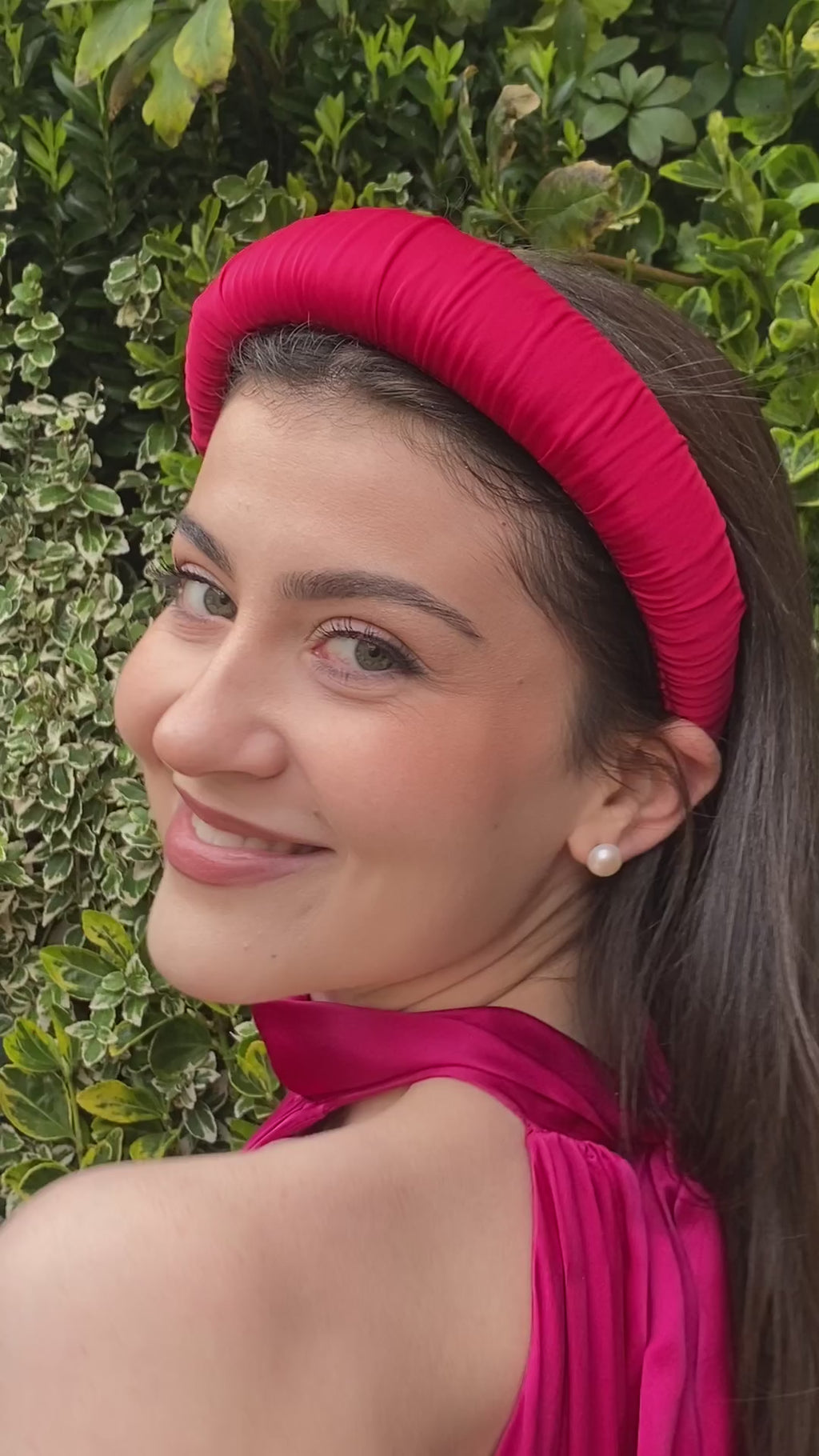 a raspberry dark pink satin padded headband that is timeless and elegant worn by model in a video beautifully showing how to style it with our glamorous evening dress