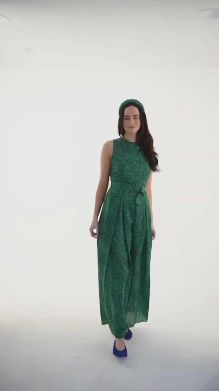 Video of sleeveless wide leg silk cotton jumpsuit and matching belt that comes in a vibrant green print.