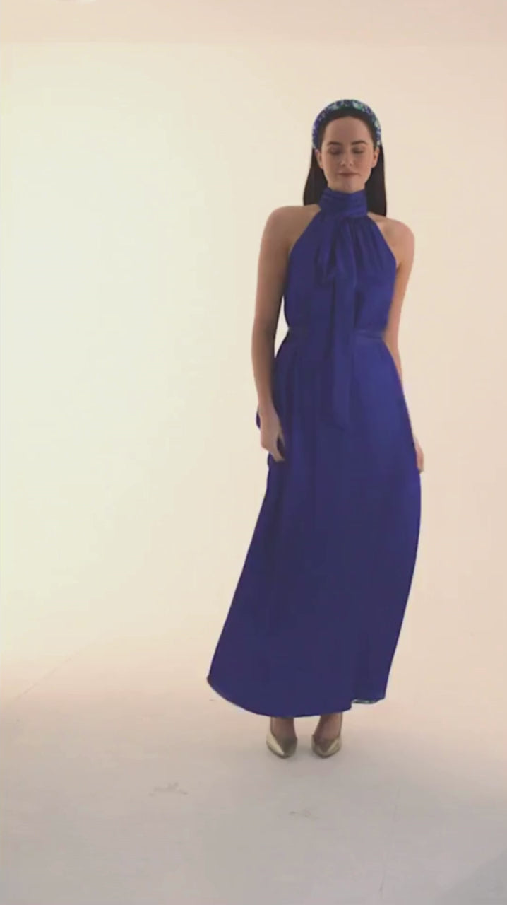 a video showing the glamorous cobalt blue silk long halter neck dress swirling in circles