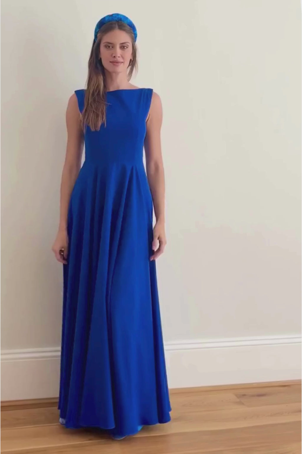 a stunning cobalt blue gown with low v-back on a model showing the glamour of this dress as it is in movement