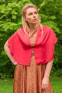 Model wearing reversible raspberry pink silk satin shawl with pearl fastener at the chest, with Neon Light padded headband and matching Victoria Gown.