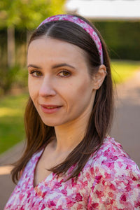 a pale pink printed headband worn by a model with matching dress