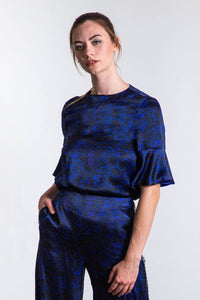 An Isabel Manns reversible peplum sleeve silk satin top with round neckline in black camo print.