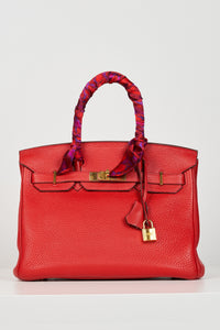 a skinny scarf accessorised on a handle of a birkin bag for extra detail and colour
