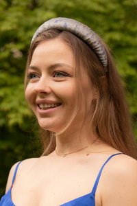 A padded headband that has a shimmer to the jacquard thread work catches the light perfectly, adding a touch of sparkle and elegance to your outfit as shown by a model