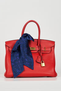 a navy printed tie scarf accessorised as a bow on a bag
