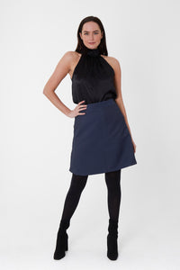 a black halter neck top paired with a blue waffle short skirt.