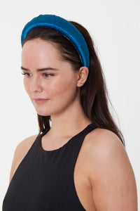 An elegant and stylish teal silk satin headband worn by a model