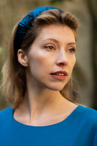 An elegant and stylish teal printed silk satin headband worn by a model