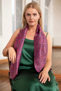 Model wearing long double sided silk satin scarf in pink/purple dotted print.