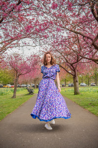 Model wearing reversible voluminous a-line midi silk satin vibrant purple print skirt, worn with matching v-neck Eleanor Top.