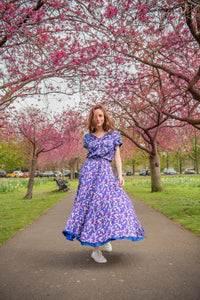 Model wearing reversible v-neck silk satin top with elbow length sleeves in vibrant purple print, worn with matching Emma Skirt Violet Marinace.