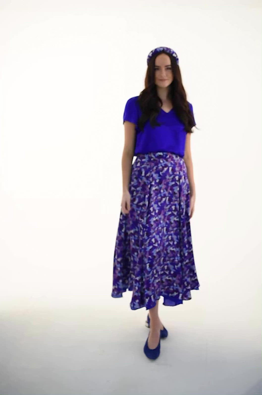 Video of model wearing reversible voluminous a-line midi silk satin vibrant cobalt skirt, worn with matching padded headband and v-neck cobalt Eleanor Top.